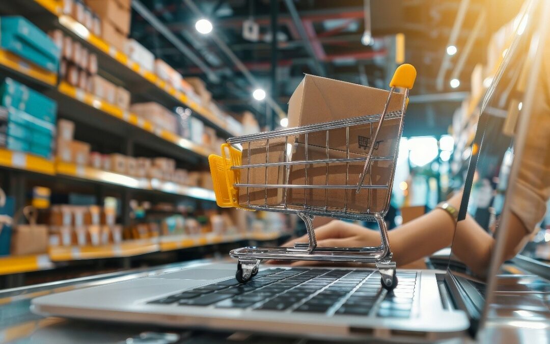 Carrito de compras con cajas de cartón sobre un portátil